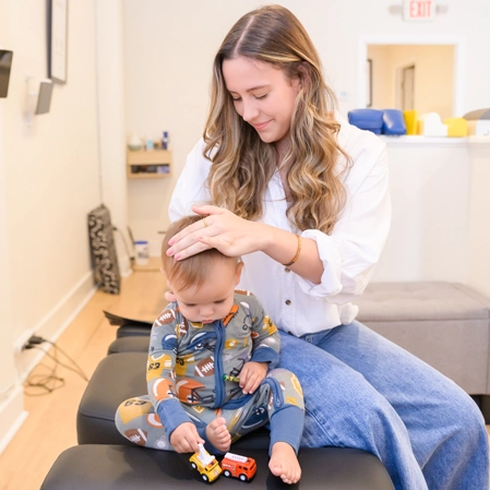 Leah Sweet adjusting a toddler.
